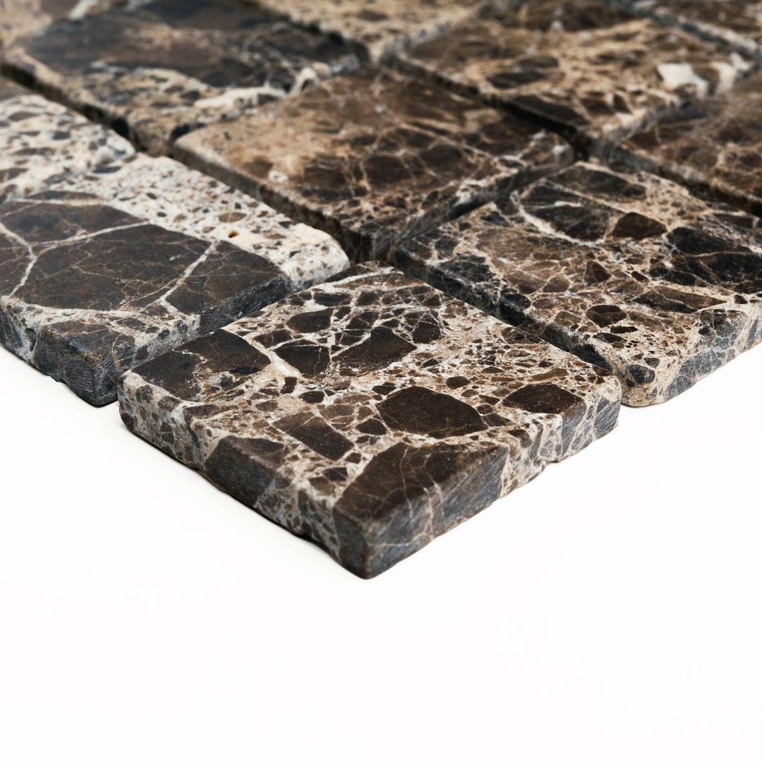 Tumbled 2 inch square Emperador Dark marble mosaic, corner shot to showcase its natural variation and softened edges with a timeless, earthy feel.