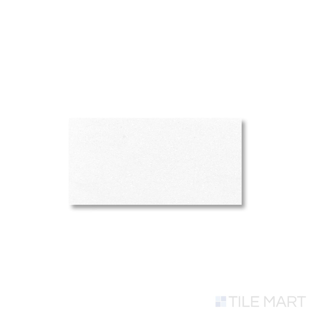 Polished Thassos White Marble 3x6 tile viewed from above, showcasing crisp white coloration and a radiant reflective surface.