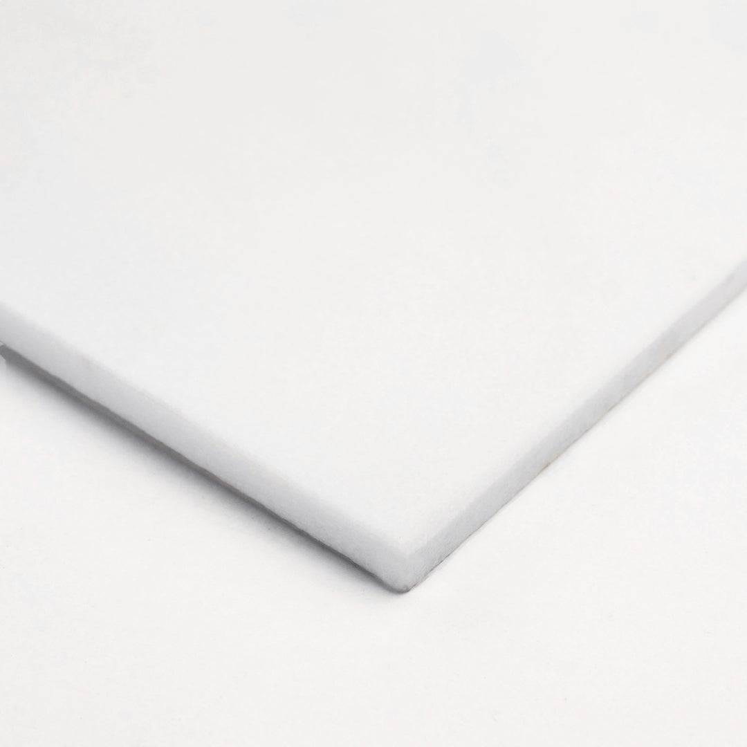 12x24 polished Thassos White marble tile shown corner-on, highlighting its mirrored finish and seamless white body for a sleek, modern aesthetic.