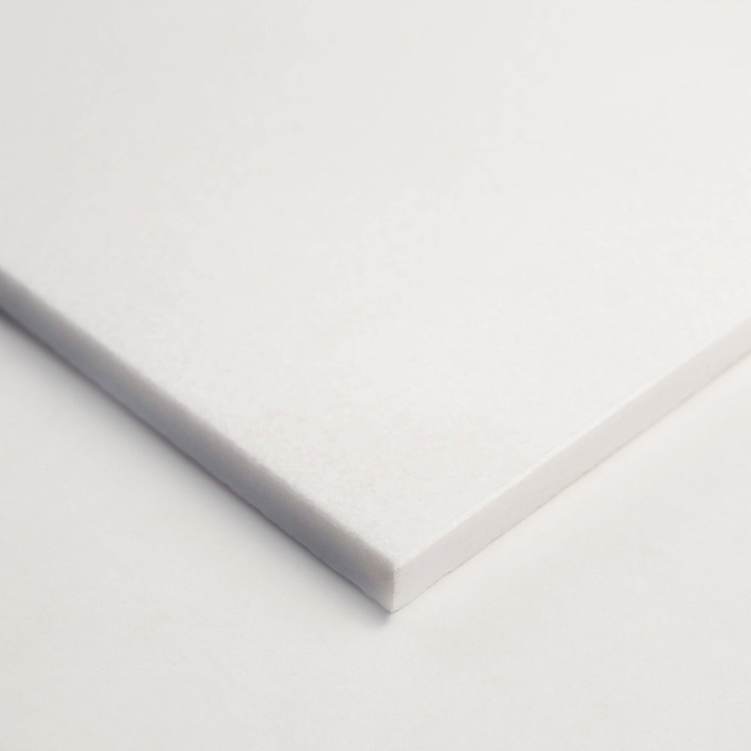 24x24 honed Thassos White marble tile in a corner shot, spotlighting its generous format and smooth, soft-white finish ideal for open spaces.