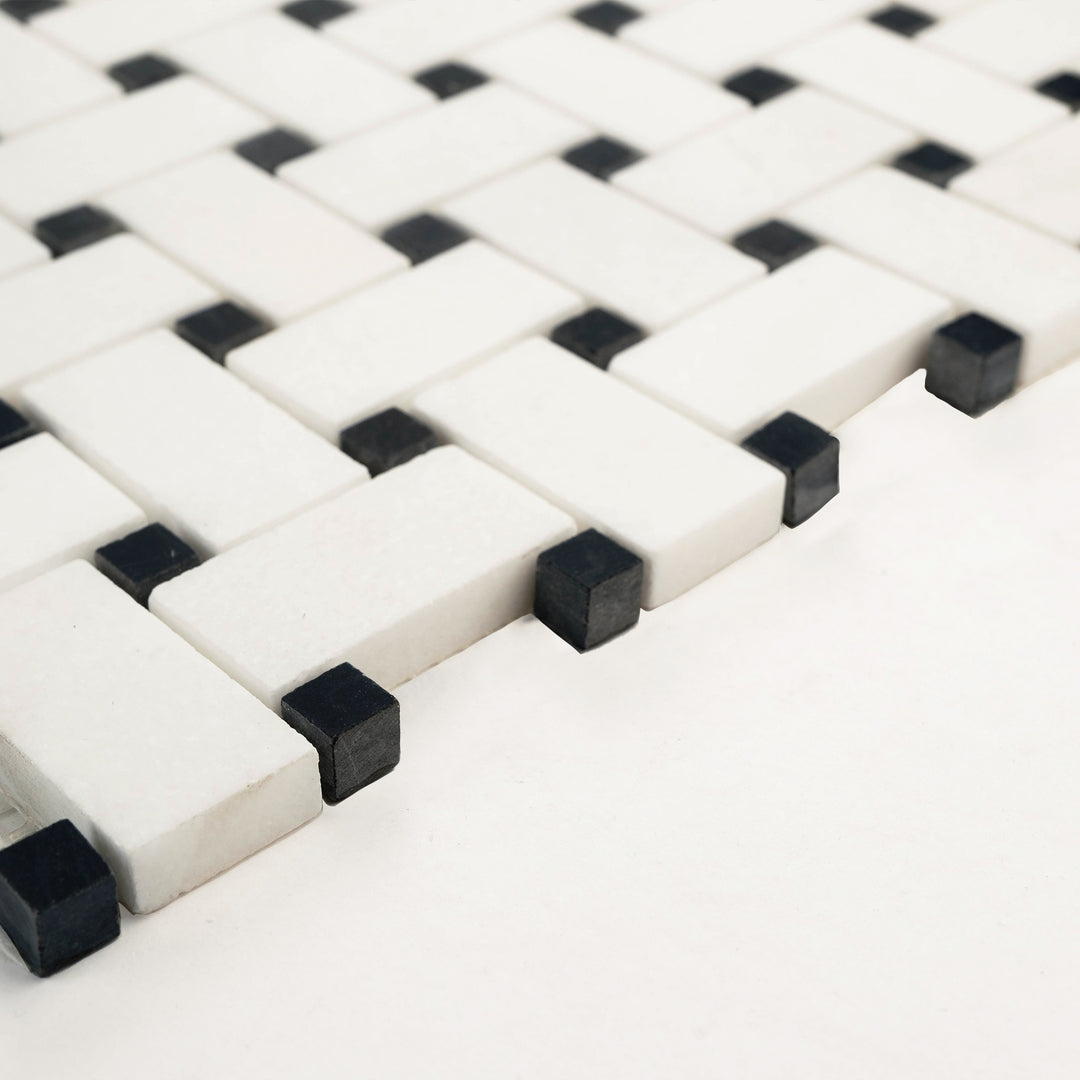 Thassos White marble basketweave mosaic with black dot, honed finish, shown at an angle to reveal clean interlocking lines and soft matte surface.