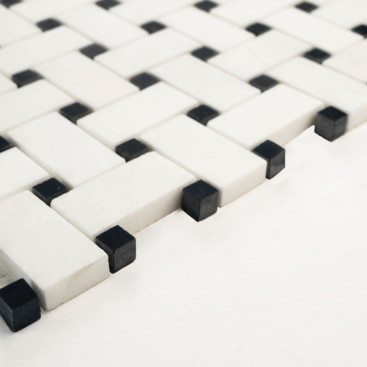 Thassos White marble basketweave mosaic with black dot, honed finish, shown at an angle to reveal clean interlocking lines and soft matte surface.
