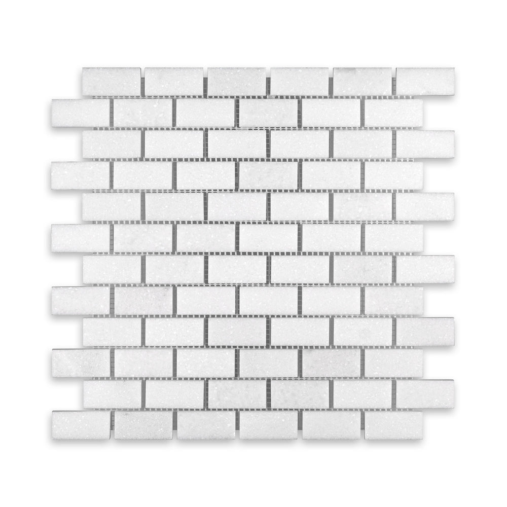 Top-down image of Thassos White Marble 1x2 brick mosaic in honed finish, highlighting soft veining and uniform rectangular pattern in radiant white.