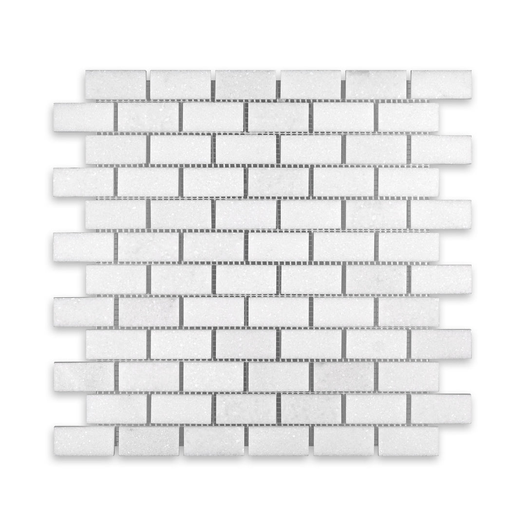Top-down image of Thassos White Marble 1x2 brick mosaic in honed finish, highlighting soft veining and uniform rectangular pattern in radiant white.