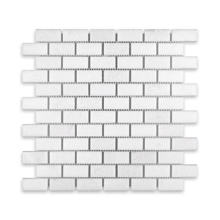 Top-down image of Thassos White Marble 1x2 brick mosaic in honed finish, highlighting soft veining and uniform rectangular pattern in radiant white.