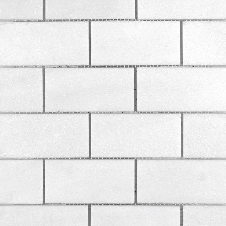 Overview of Thassos White Marble 2x4 Brick Honed Mosaic presenting a subdued matte finish in a classic rectangular format.