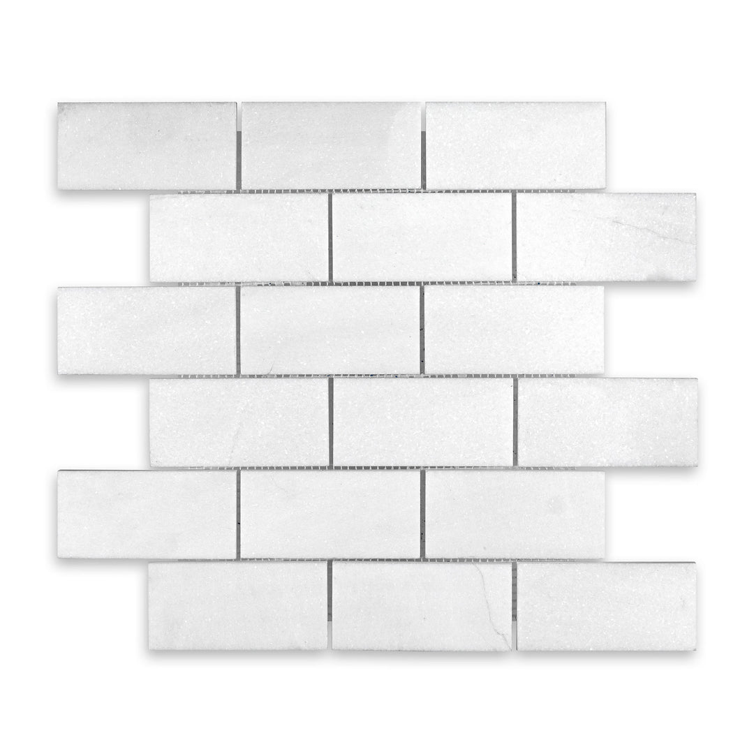 Overhead view of Thassos White Marble 2x4 brick mosaic in honed finish, presenting a larger brick format with smooth texture and crisp white color.