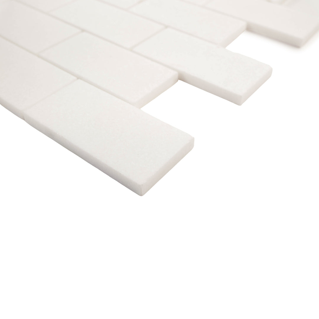 2x4 honed brick mosaic in Thassos White marble, corner view emphasizes elongated format and minimalist matte elegance.