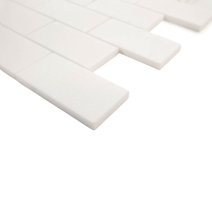 2x4 honed brick mosaic in Thassos White marble, corner view emphasizes elongated format and minimalist matte elegance.