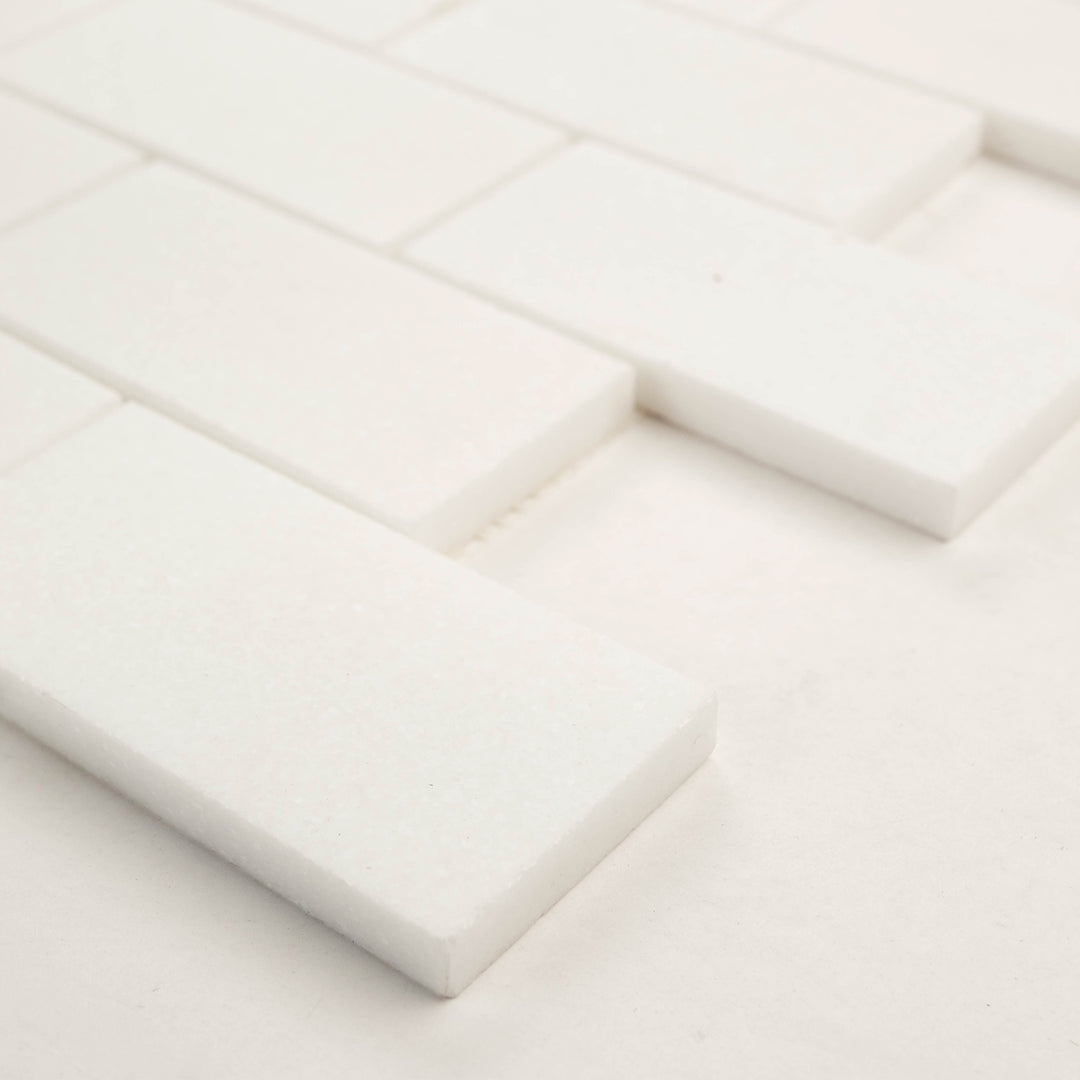 2x4 brick mosaic in polished Thassos White marble, shown corner-on to reflect its bright surface and precise spacing.