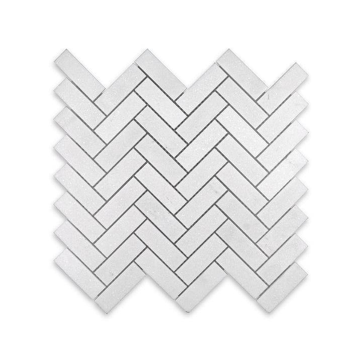 Overhead image of 1x3 herringbone mosaic in honed Thassos White Marble, showing elongated pieces and a classic interlocking layout with soft finish.