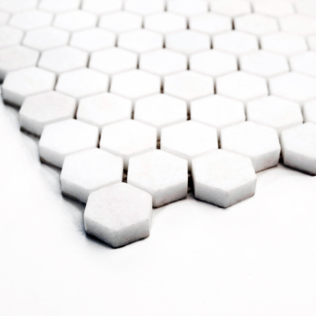 1" hexagon mosaic in honed Thassos White marble, shown from a corner to enhance depth and subtle texture of the surface.