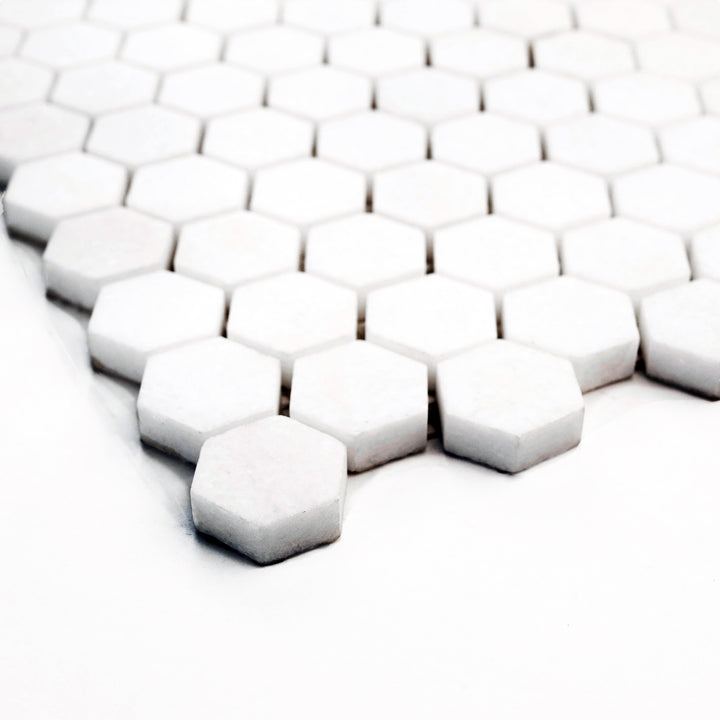1" hexagon mosaic in honed Thassos White marble, shown from a corner to enhance depth and subtle texture of the surface.