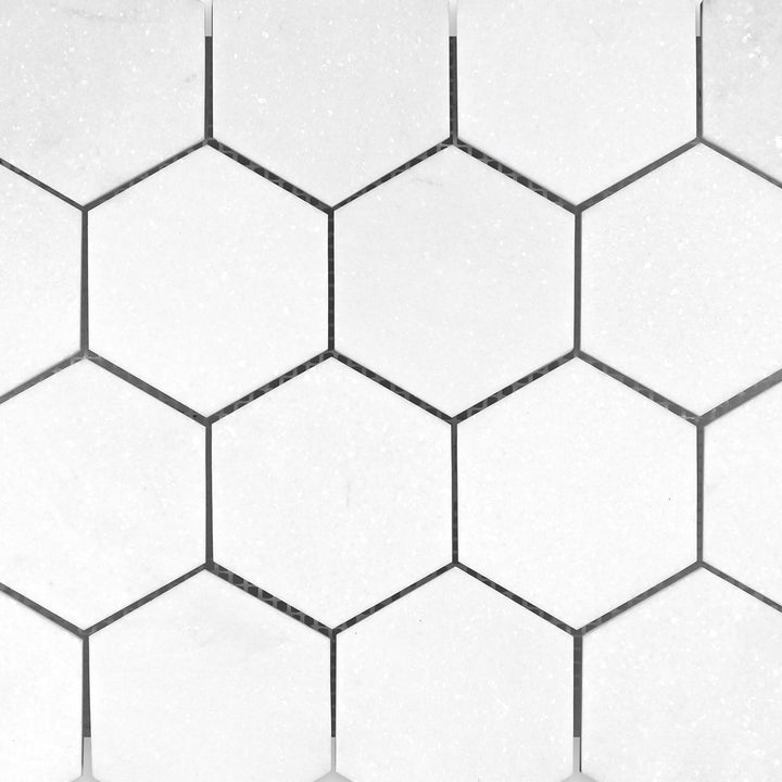Full view of Thassos White Marble 3" Hexagon Honed Mosaic displaying oversized matte white hex tiles in a minimalist geometric pattern.