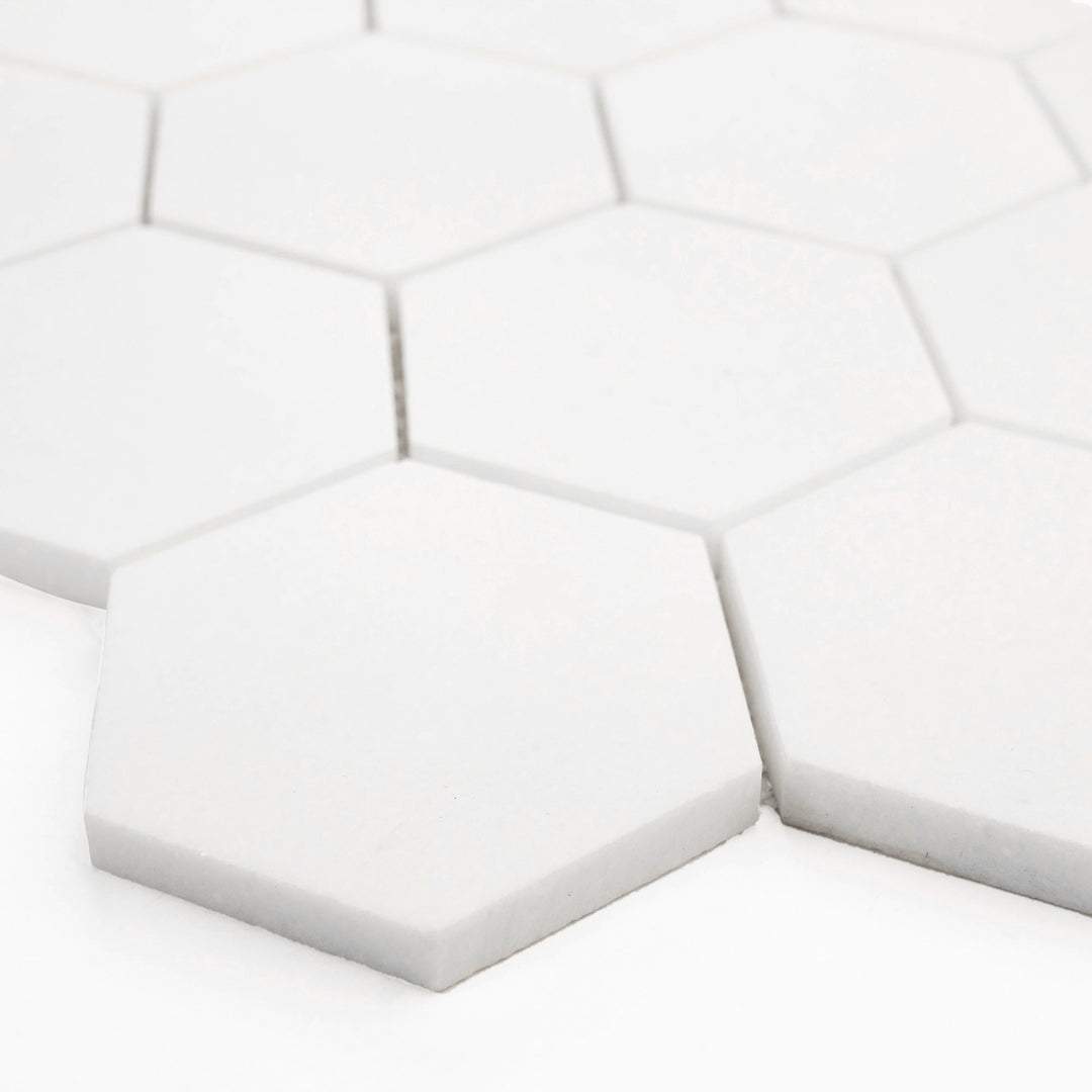 Angled corner shot of Thassos White Marble 3-Inch Hexagon Honed Mosaic Tile, revealing its matte finish and clean geometric styling suited for modern interiors.