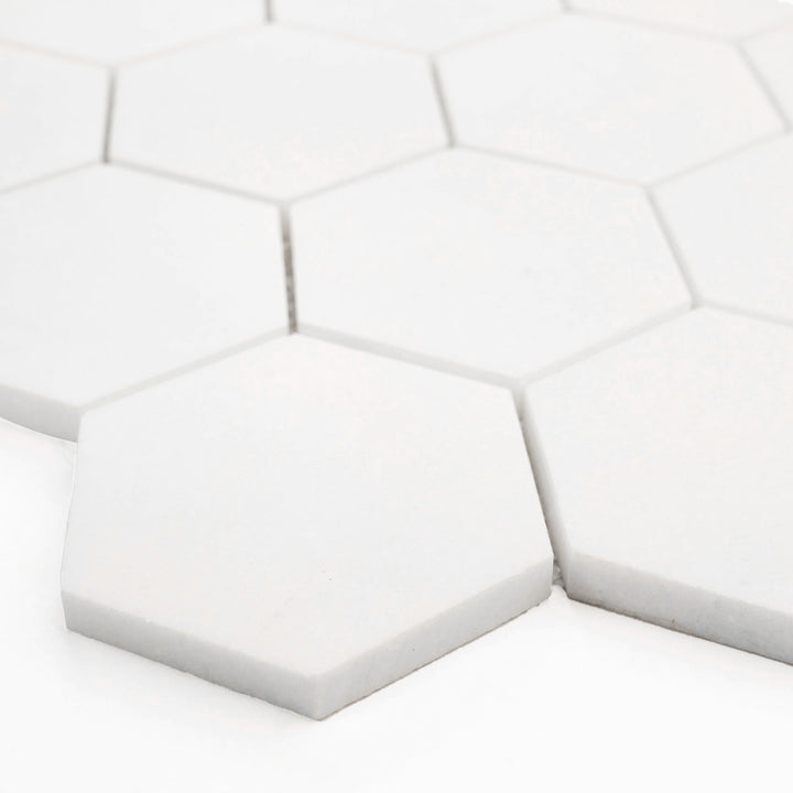 Angled corner shot of Thassos White Marble 3-Inch Hexagon Honed Mosaic Tile, revealing its matte finish and clean geometric styling suited for modern interiors.