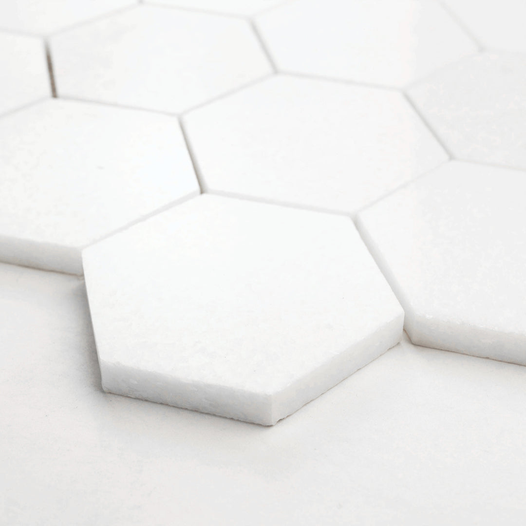Thassos White Marble 3-Inch Hexagon Polished Mosaic Tile captured from a corner perspective, emphasizing its glossy surface and precise marble veining.