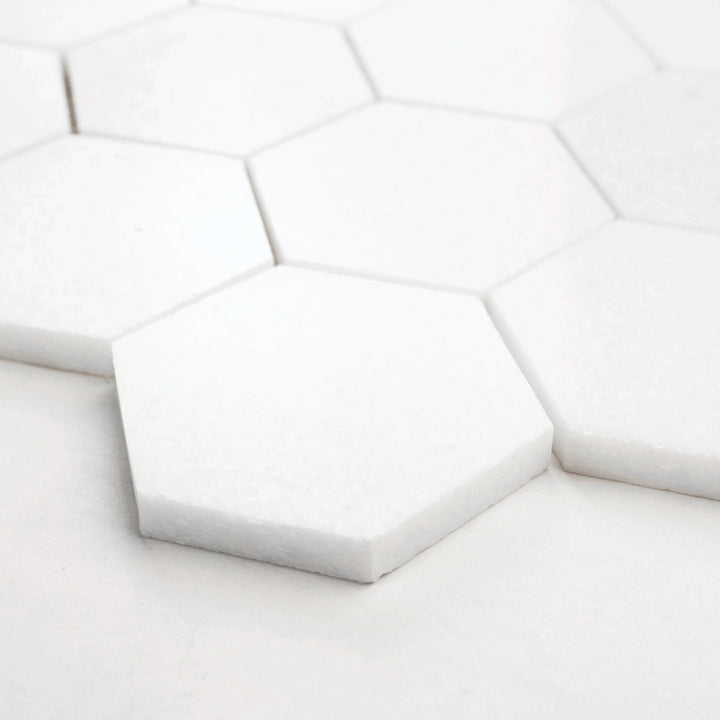 Thassos White Marble 3-Inch Hexagon Polished Mosaic Tile captured from a corner perspective, emphasizing its glossy surface and precise marble veining.
