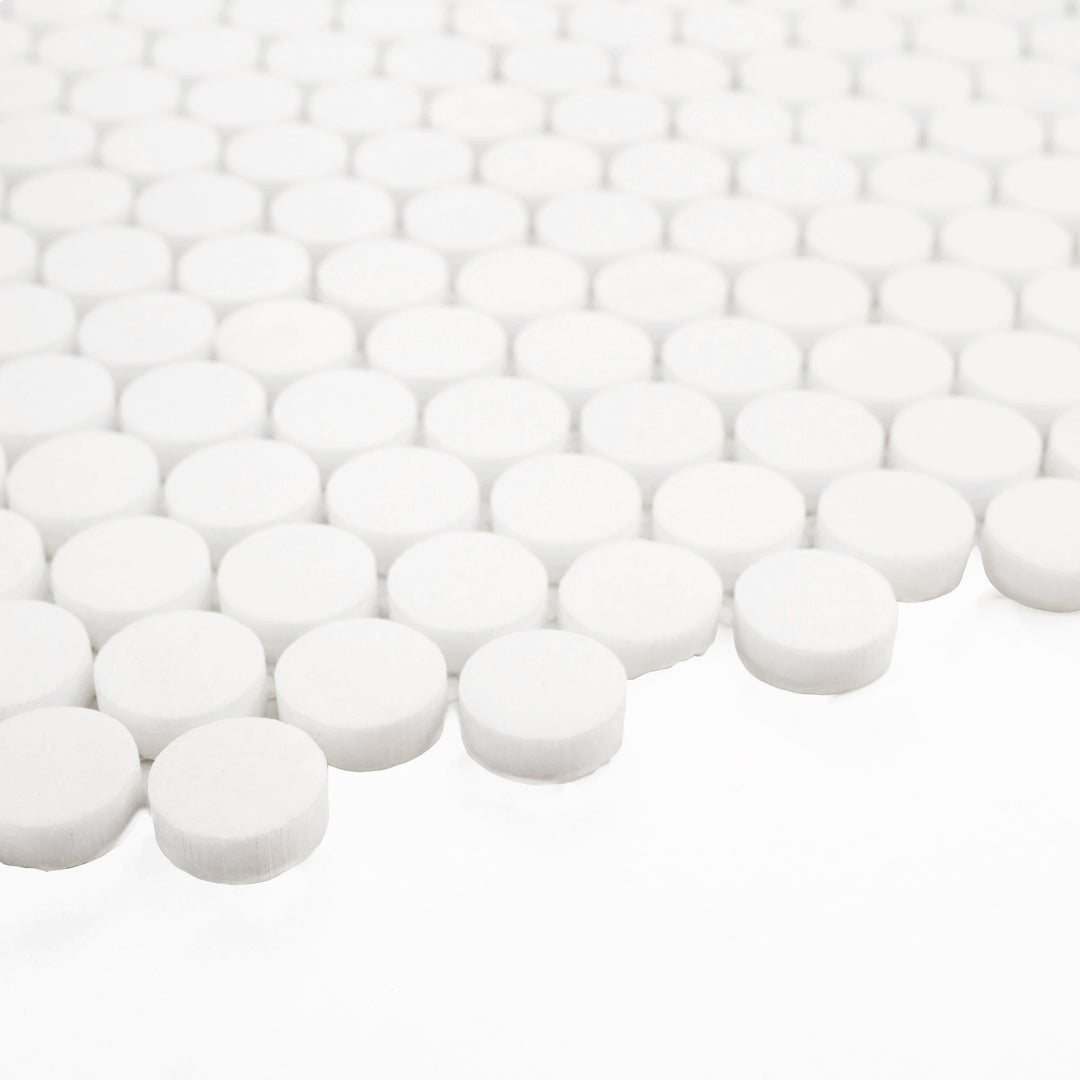 With a corner view, this Thassos White Marble Penny Round Honed Mosaic Tile showcases its soft honed texture and timeless round pattern—ideal for elegant wall and floor accents.