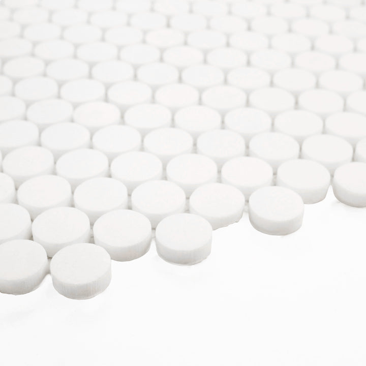 With a corner view, this Thassos White Marble Penny Round Honed Mosaic Tile showcases its soft honed texture and timeless round pattern—ideal for elegant wall and floor accents.