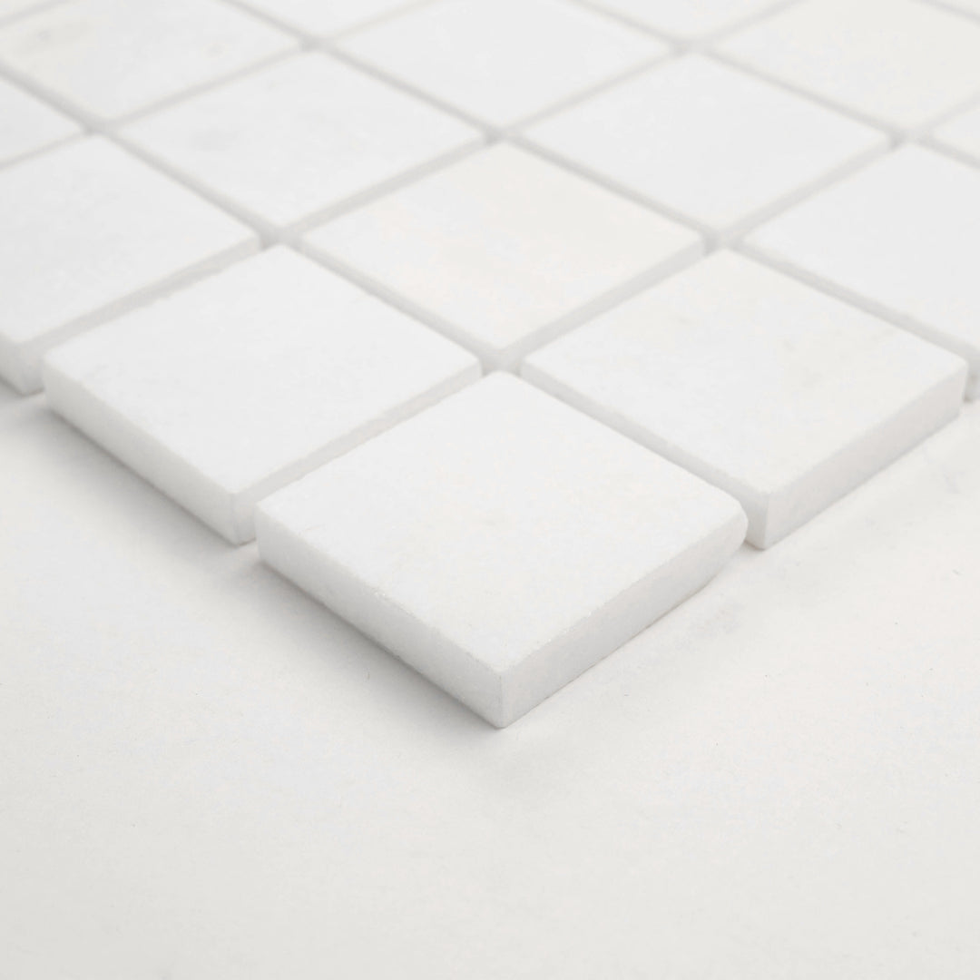 Angled view of Thassos White Marble 2-Inch Square Honed Mosaic Tile, displaying a natural matte look and balanced layout—ideal for contemporary bathrooms and kitchens.
