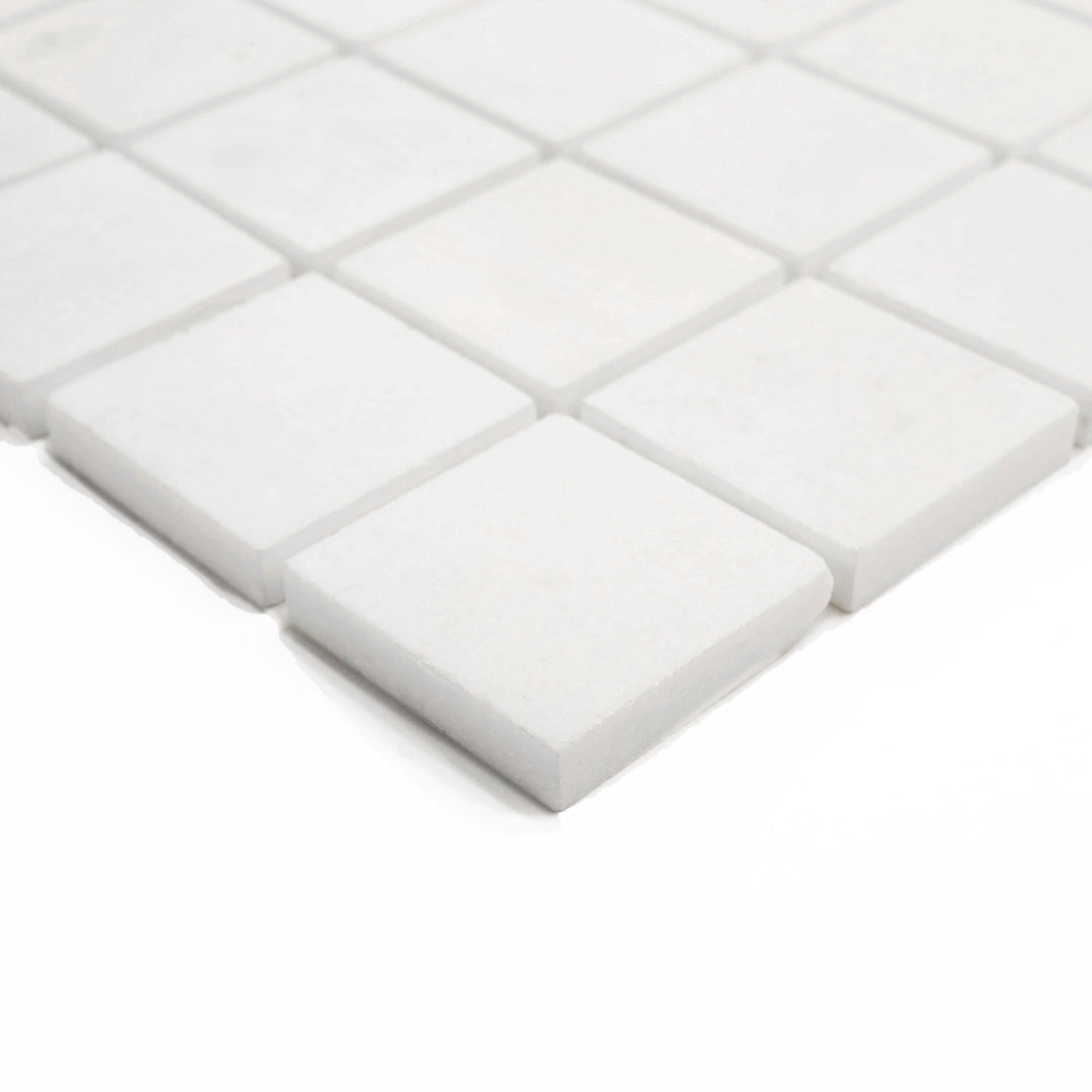 Corner shot of Thassos White Marble 2-Inch Square Polished Mosaic Tile, emphasizing the sleek, reflective finish and precision-cut square layout for luxury applications.