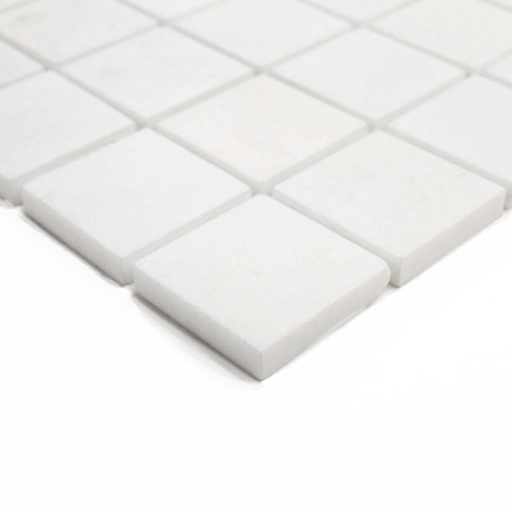 Corner shot of Thassos White Marble 2-Inch Square Polished Mosaic Tile, emphasizing the sleek, reflective finish and precision-cut square layout for luxury applications.
