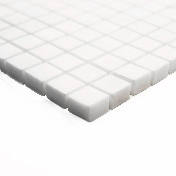 This angled corner perspective of Thassos White Marble 5/8-Inch Square Honed Mosaic Tile highlights its fine-scale matte texture and crisp pattern for detailed installations.