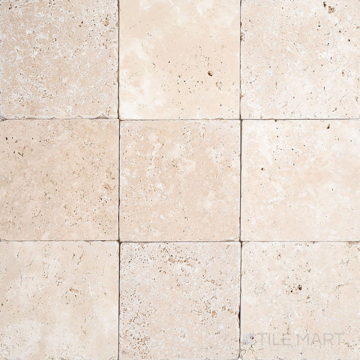 Overview of Ivory Premium Travertine 4x4 Tumbled Tile with soft, worn edges and a naturally aged surface texture.