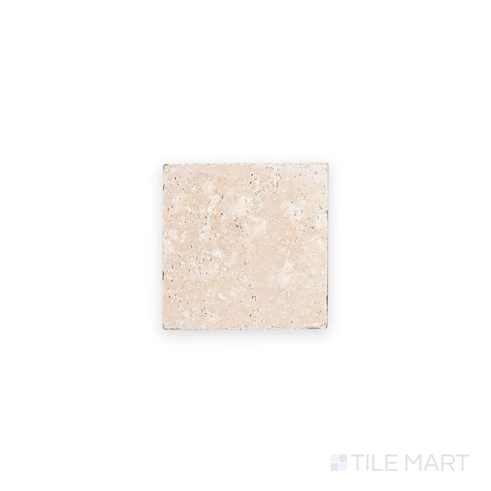 Overhead shot of Ivory Premium Travertine 4x4 tile in tumbled finish, revealing weathered edges and earthy tones with a naturally aged appearance.