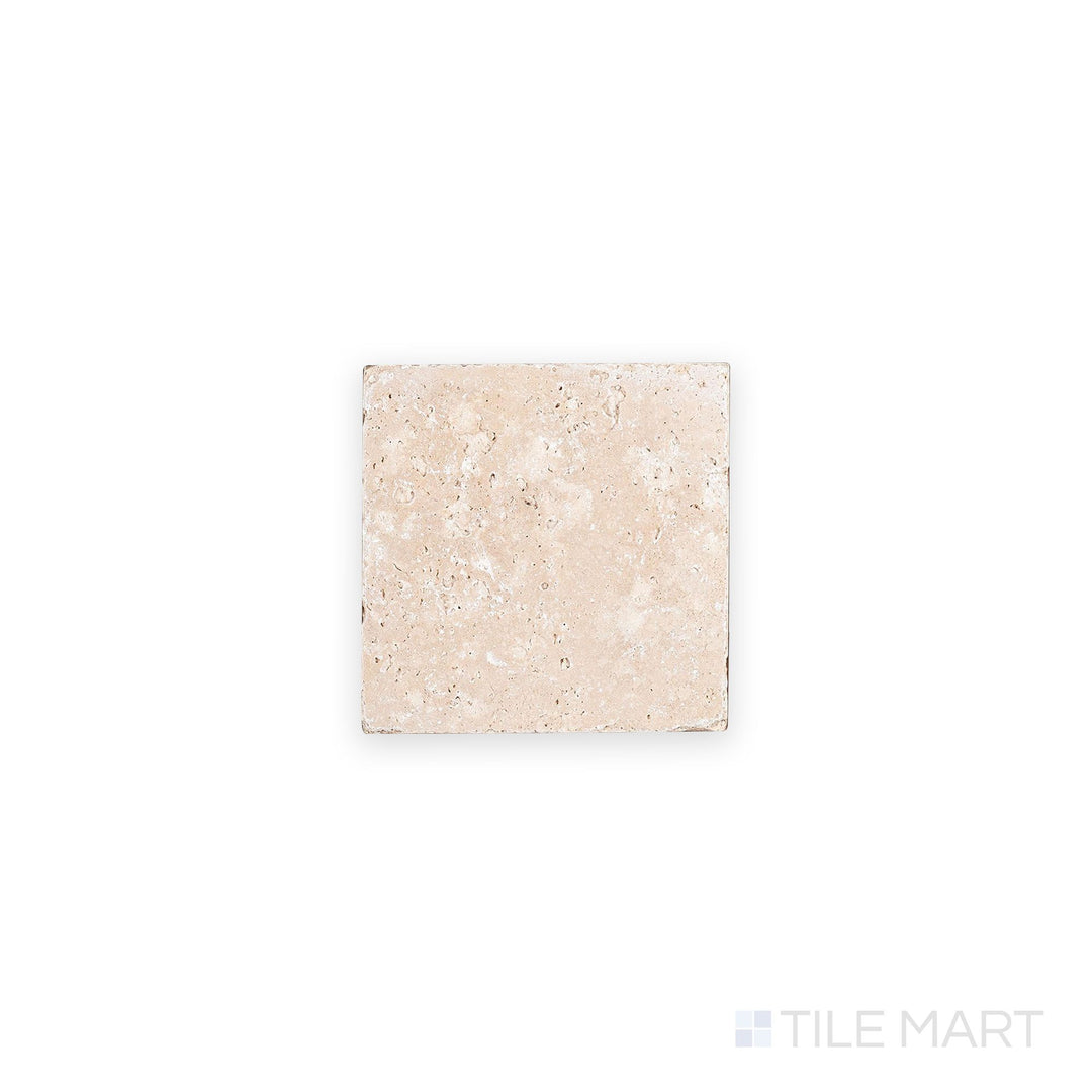 Overhead shot of Ivory Premium Travertine 4x4 tile in tumbled finish, revealing weathered edges and earthy tones with a naturally aged appearance.