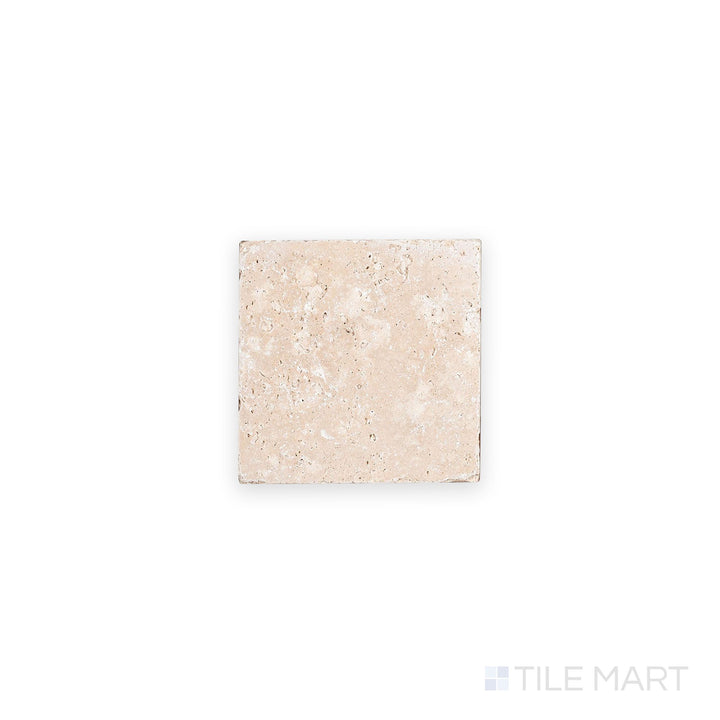 Overhead shot of Ivory Premium Travertine 4x4 tile in tumbled finish, revealing weathered edges and earthy tones with a naturally aged appearance.