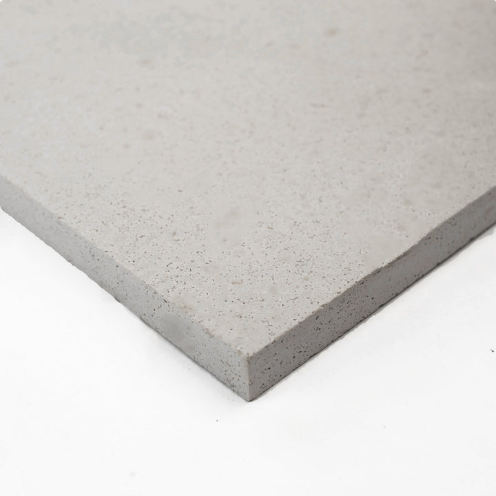 Corner view of Crema Europa Limestone 24x24 Honed Tile, showcasing its soft beige tones and smooth finish—perfect for sophisticated floor and wall designs.