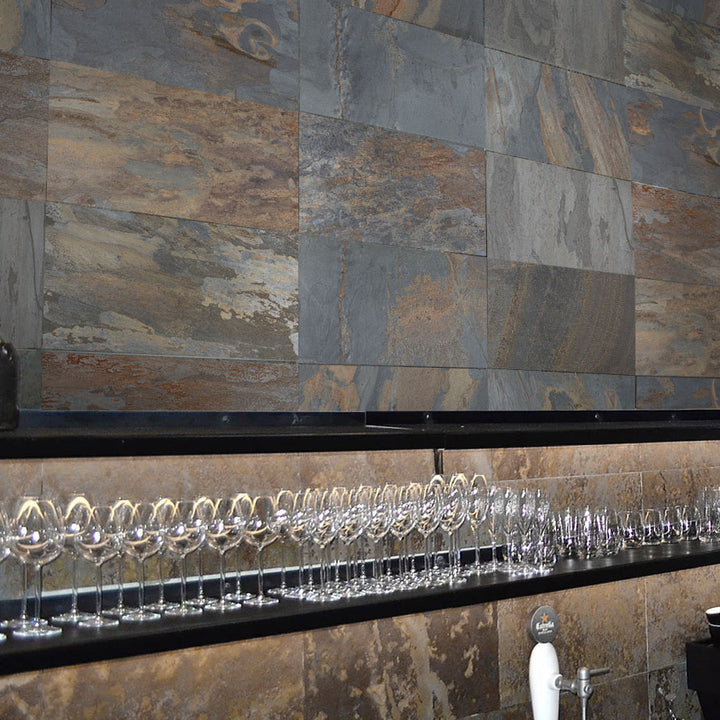 Row of wine glasses on a bar counter with a stone wall background