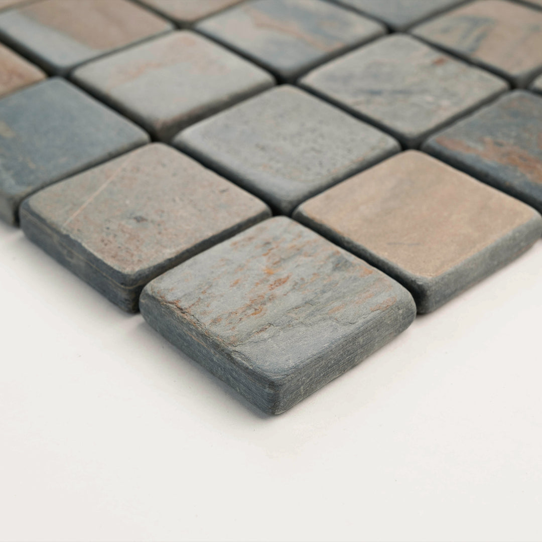 Angled corner shot of California Gold Slate 2-Inch Square Tumbled Mosaic Tile, capturing the rustic charm and vibrant natural colors for backsplashes or shower floors.