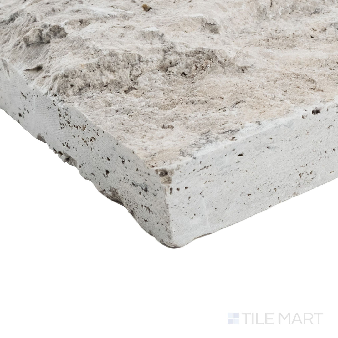 Silver travertine 8x7.5 corner veneer shown at corner angle with rugged splitface texture and architectural profile