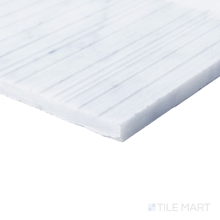 Corner detail of Ravello White Carrara marble 6x24 fence tile showcasing crisp veining and architectural texture