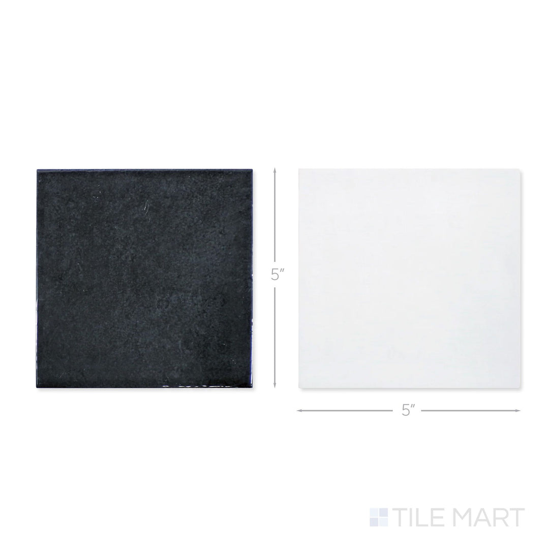Top-down view of a single Village 5x5 white and black checkerboard glossy ceramic tile showing its light-reflective surface and two-tone finish detail