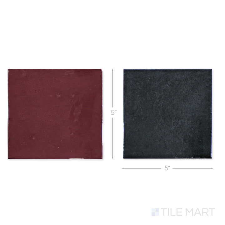 Top-down view of a single Village 5x5 aubergine and black checkerboard glossy ceramic tile showing its light-reflective surface and two-tone finish detail