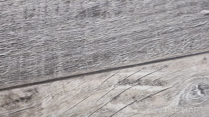 Video featuring Cyrus Bembridge 9X60 Low Gloss Luxury Plank Vinyl. A large-format wood-look vinyl plank with gray-brown tones and a smooth matte finish.