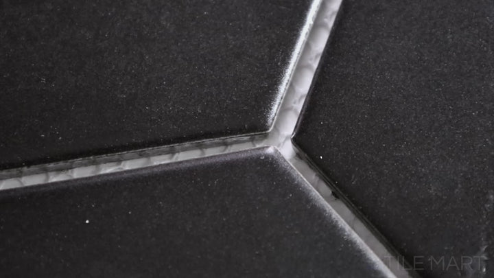 Video highlighting Porcelain Glazed Mosaics Black 4-inch Hexagon Matte. A large black matte porcelain hexagonal mosaic, creating a striking and contemporary design.