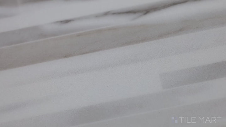 Video featuring Tele Di Marmo Reloaded Calacatta 24X48 Polished Porcelain. A luxurious white marble-effect tile with subtle grey veining, enhancing any interior space.