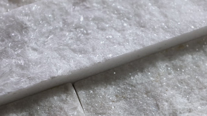 Video highlighting Natural Splitface Stackstone Panels Glacier White 6x24. A crisp white natural stone panel with a textured splitface design, creating a bright and fresh aesthetic.