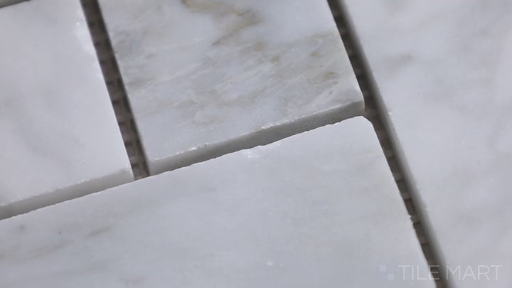 Video highlighting Sto-Re Carrara Herringbone Polished Marble Mosaic. A classic Carrara marble mosaic with a polished finish and an elegant herringbone layout.