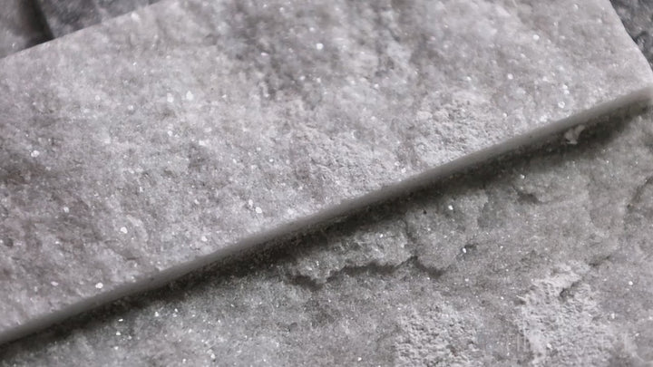 Video of Natural Splitface Stackstone Panels Alaska Grey 6x24. A natural stone panel in cool grey tones with a splitface texture, delivering a rugged and modern appeal.