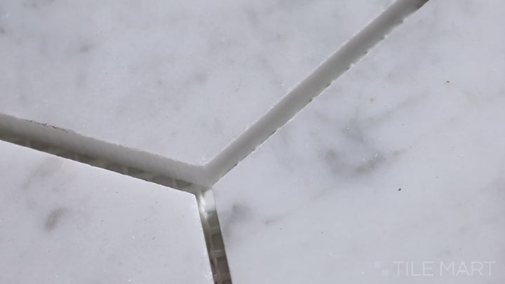 Video showcasing Sto-Re Carrara 4" Hexagon Polished Marble Mosaic. Classic Carrara marble with a refined polished finish, arranged in a large hexagonal pattern for sophisticated style.
