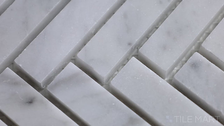 Video featuring Sto-Re Carrara Herringbone Polished Marble Mosaic. This classic Carrara marble mosaic in a herringbone pattern with a polished finish enhances spaces with timeless beauty.