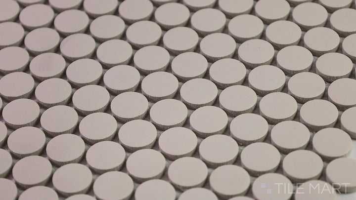 Video showcasing Marin Sand Dollar 3/4" Penny Round Matte Glazed Porcelain Mosaic. A warm beige penny round tile inspired by coastal sand tones, perfect for beachy aesthetics.