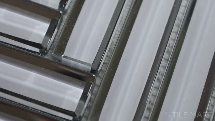 Video showcasing Modern Glass Grey Herringbone Glossy Mosaic. A sleek grey glass tile with a glossy finish, arranged in a timeless herringbone pattern for a refined, modern aesthetic.