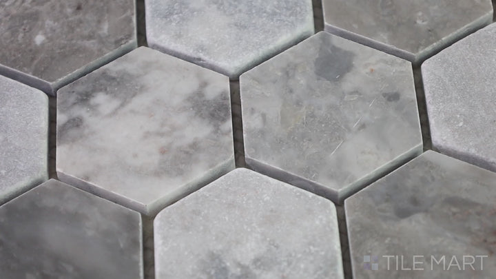 Video featuring The Finish Line Manor Gray 2" Hexagon Polished Marble Mosaic. A sleek, polished marble tile in hexagonal format, blending modern geometry with classic elegance.